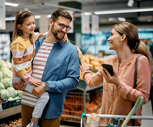 A couple grocery shopping with their son.