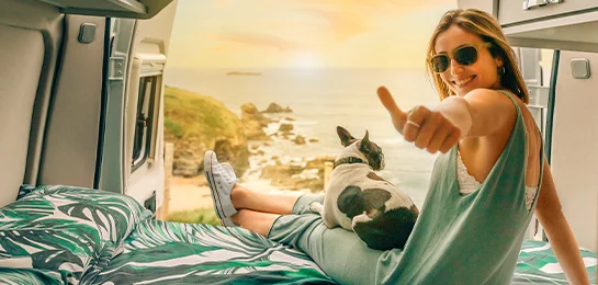 Lady smiling in a RV with her dog.