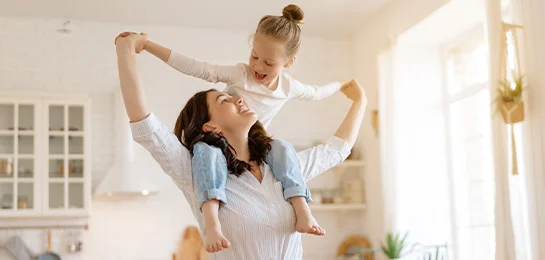 Mom giving her daughter a piggyback ride in her new home.